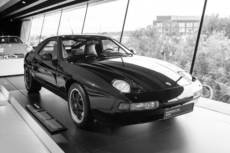 Schwarzweiss-Bild von einem Porsche 928 in einem Ausstellungsraum. Dieser klassische Sportwagen wird von dem Porsche Spezialisten Elferhus angekauft.