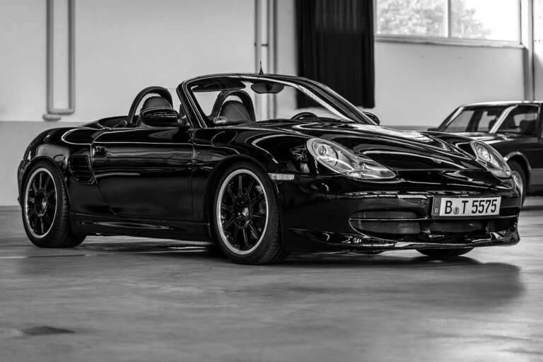 Schwarzweiss Bild von einem Porsche 986. Er präsentiert sich in einer Halle. Dieser klassische Sportwagen wird von dem Porsche Spezialisten Elferhus angekauft.