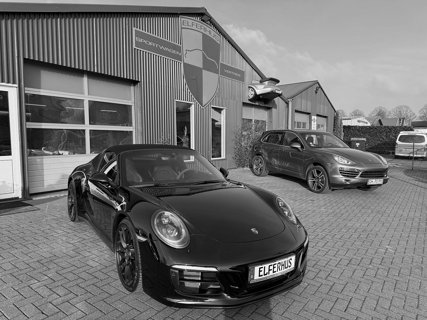 Schwarzweiss Bild eines Porsche 991 vor der Porsche Werkstatt in Ratekau. Dieser klassische Sportwagen wird von dem Porsche Spezialisten Elferhus angekauft.