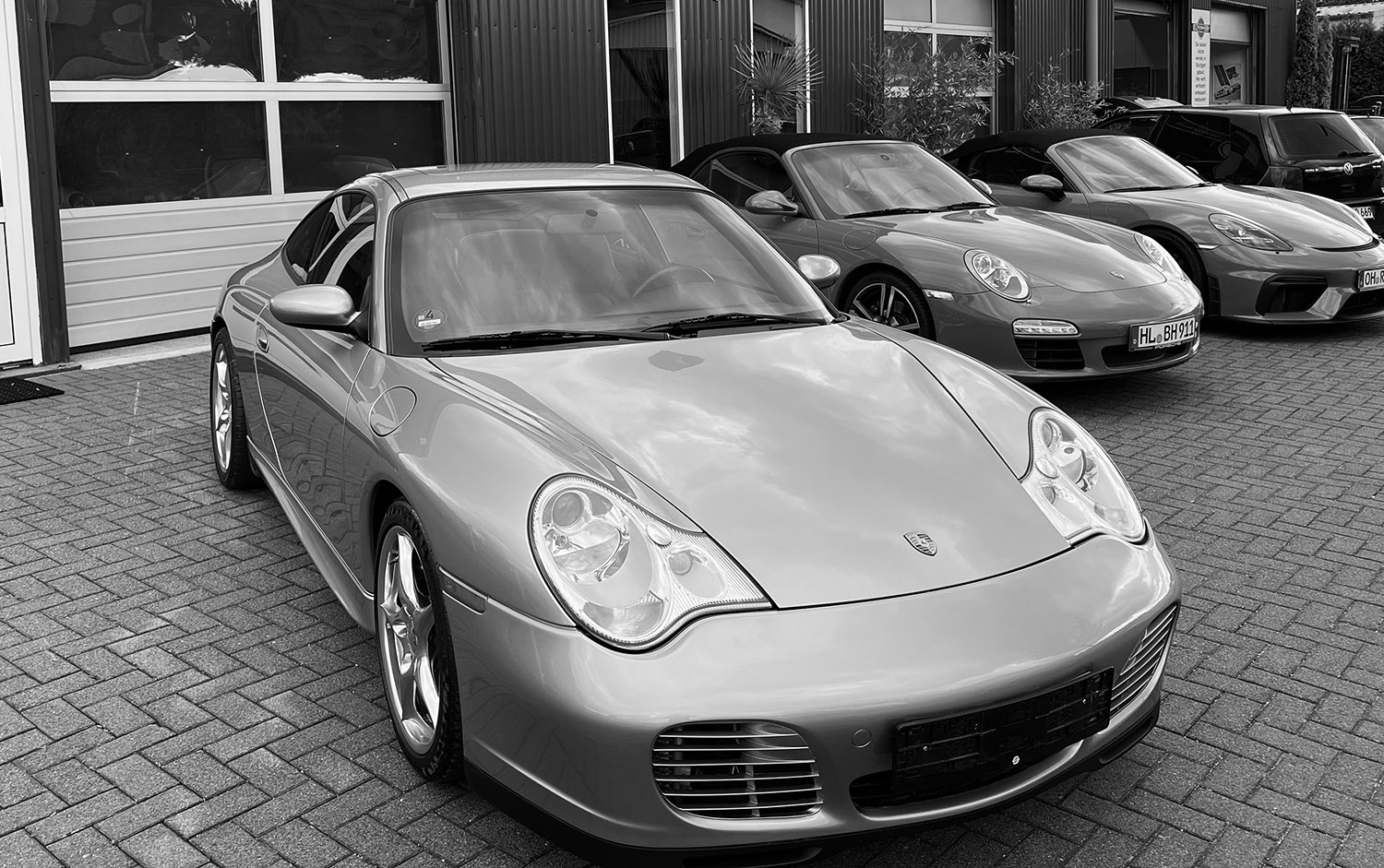 Schwarzweiss Bild eines Porsche 996 vor der Porsche Werkstatt in Ratekau. Dieser klassische Sportwagen wird von dem Porsche Spezialisten Elferhus angekauft.